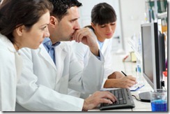 Group of scientists working on computer in laboratory.